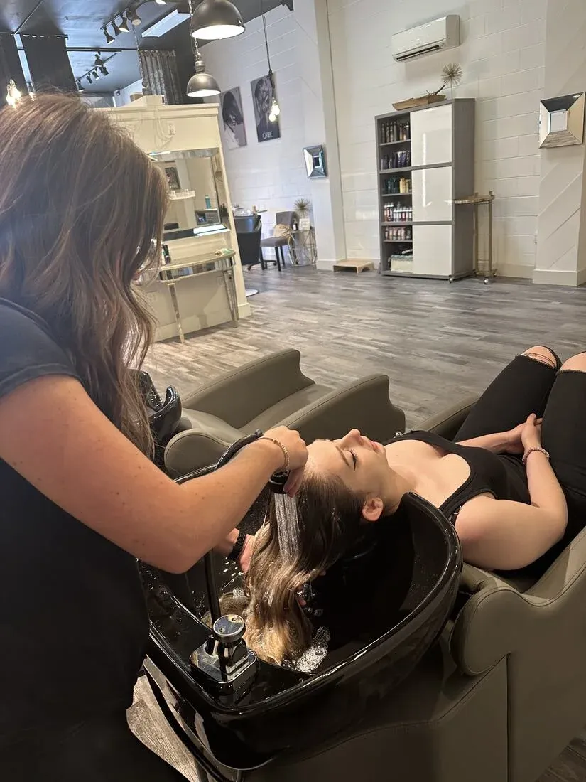 A stylist holding extension hair at Salon Bilancio