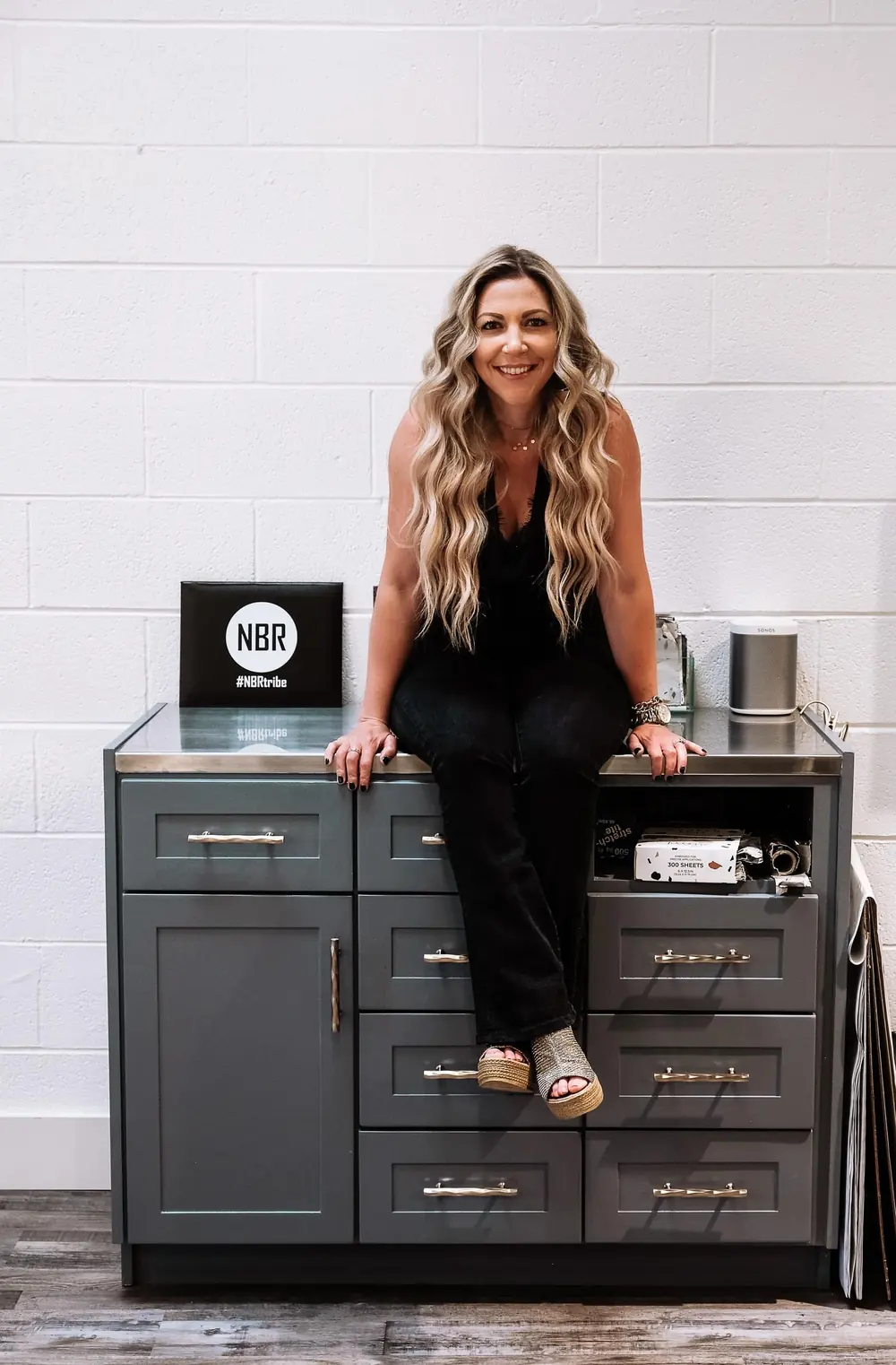 Nina Pelfini beside the NBR sign in the salon